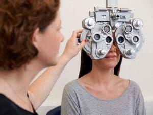 Augenoptikerin macht Sehtest bei einer Kundin